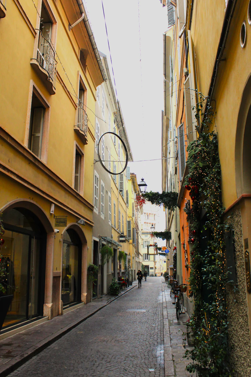 Narrow street between tall buildings with almost no one on it