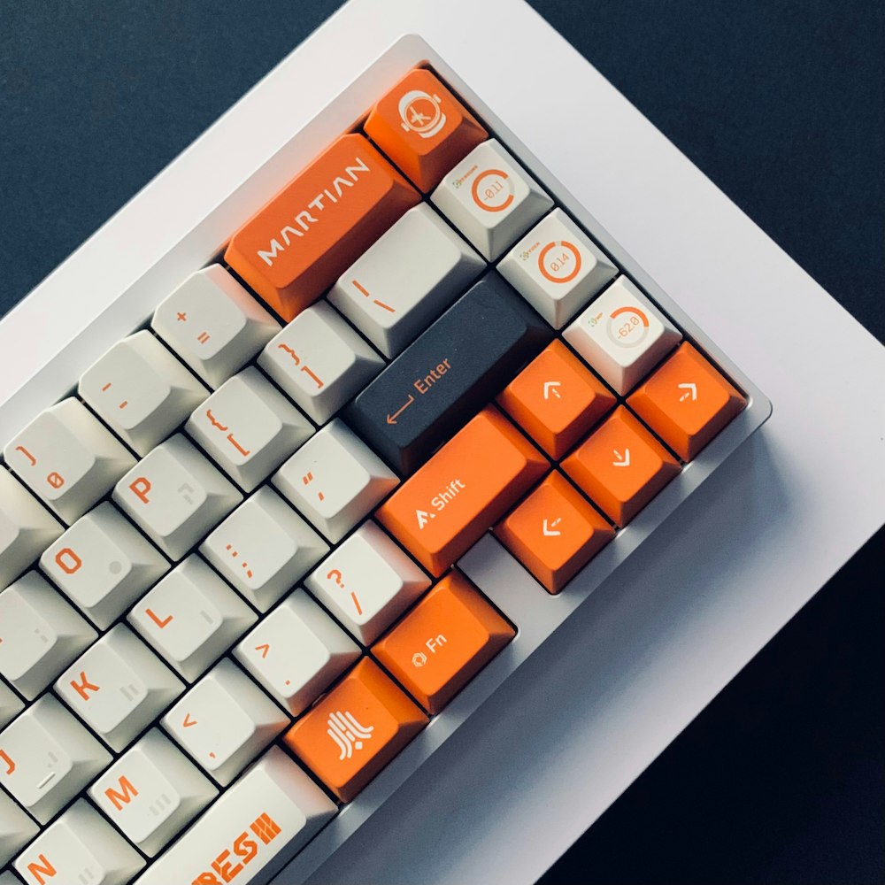 a close up of a computer keyboard with orange keys