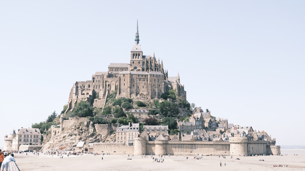 a very tall castle sitting on top of a sandy beach