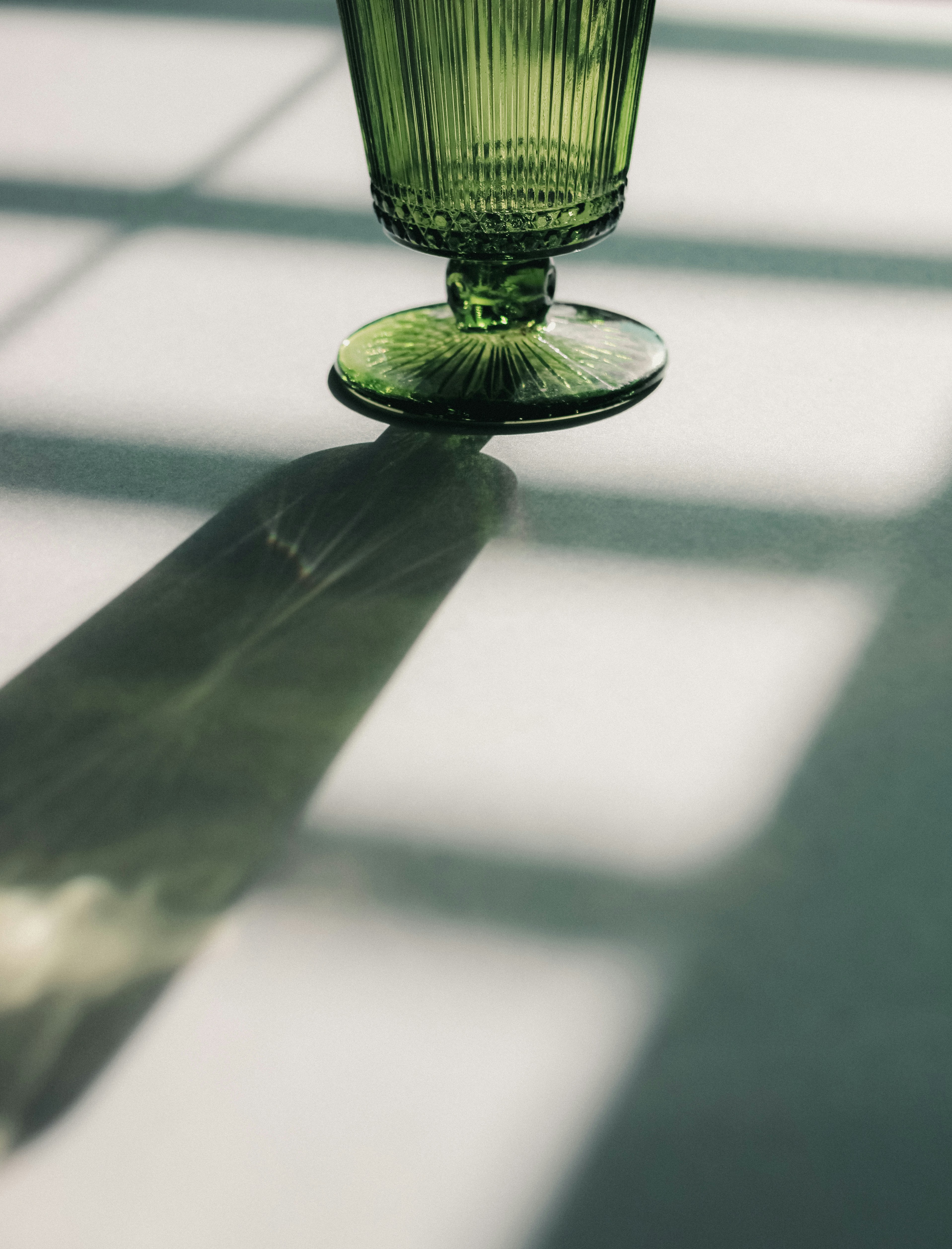 A green glass sitting on top of a table photo – Free Glass Image on ...