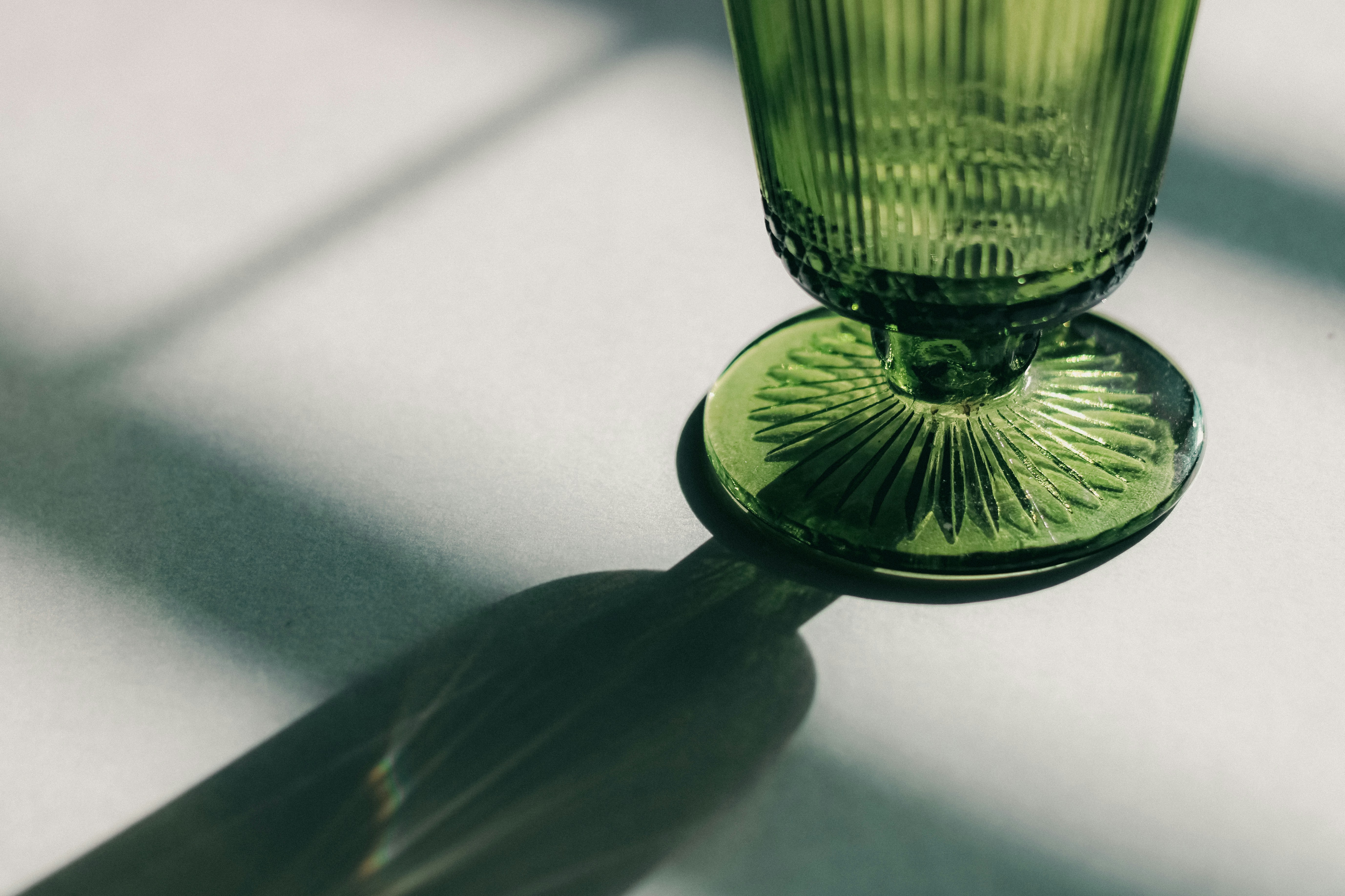 A green glass sitting on top of a table photo – Free Glass Image on ...