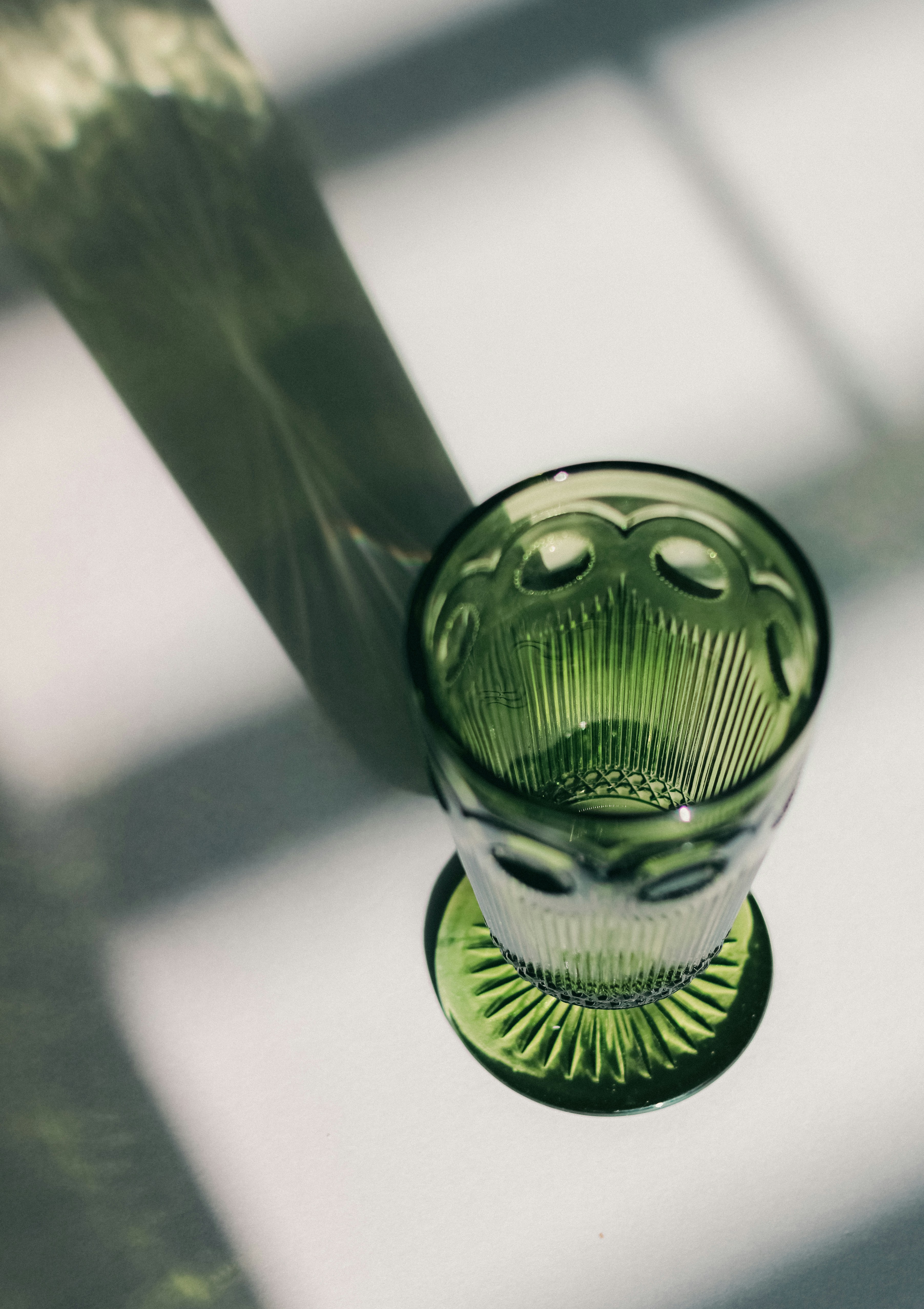 A green glass sitting on top of a table photo – Free Grey Image on Unsplash