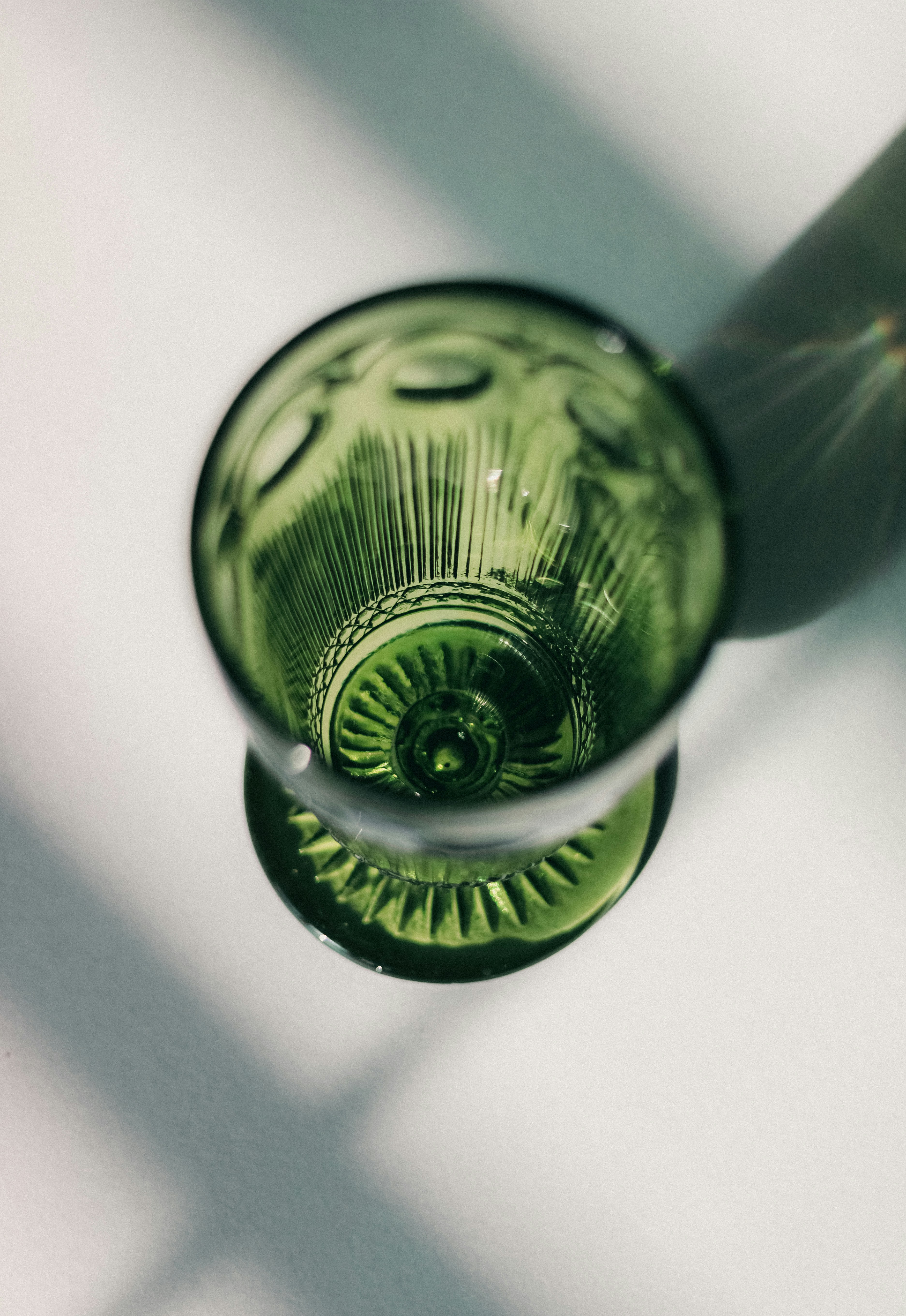 A green glass sitting on top of a table photo – Free Glass Image on ...
