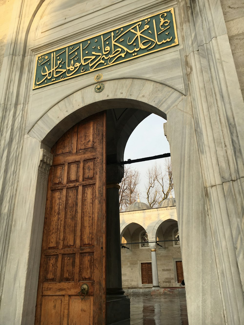 a large wooden door with arabic writing on it