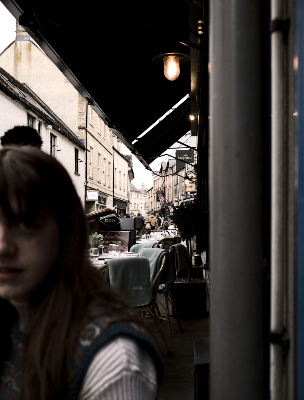 a woman standing outside of a restaurant looking at the camera