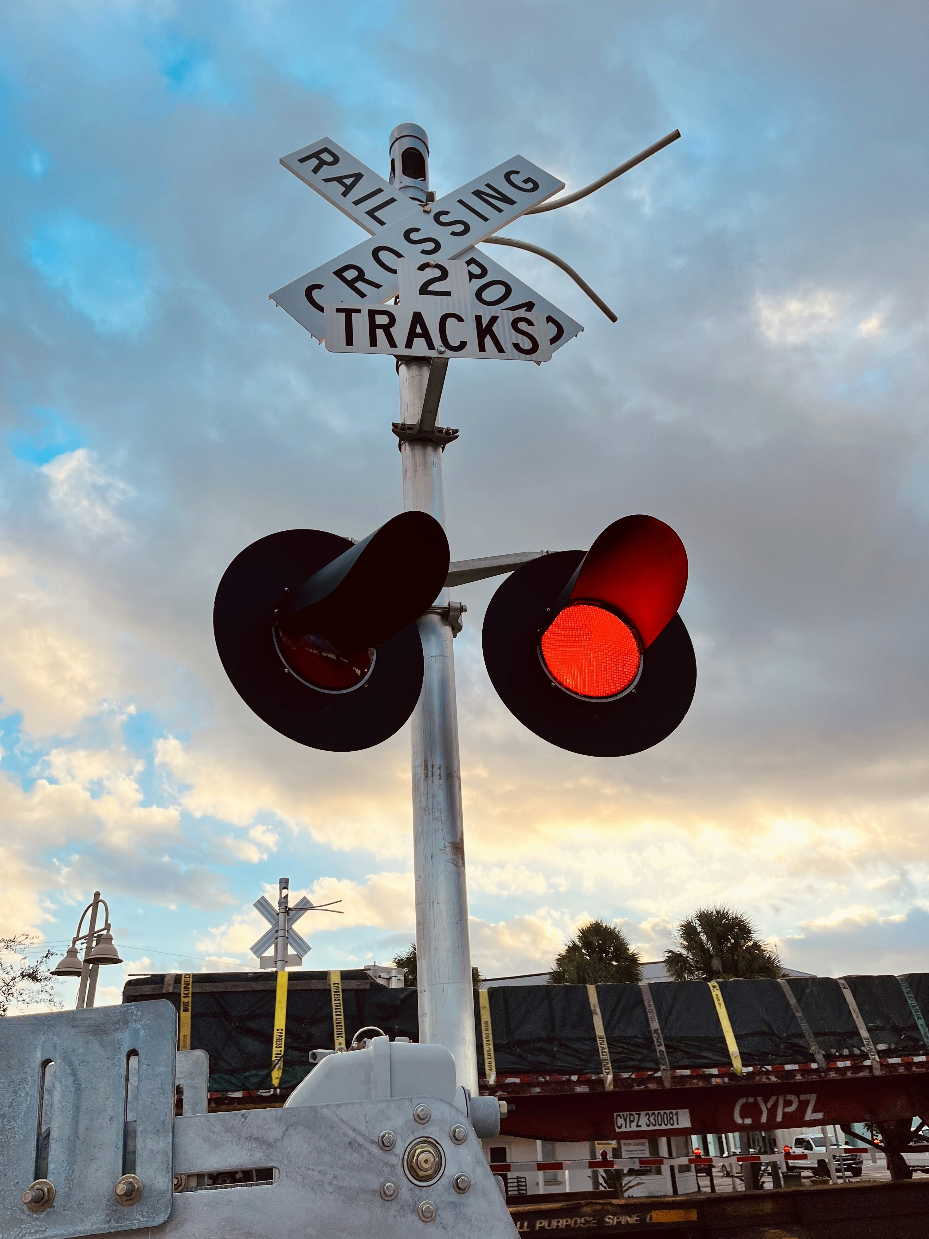 a traffic light with a railroad crossing sign in the background