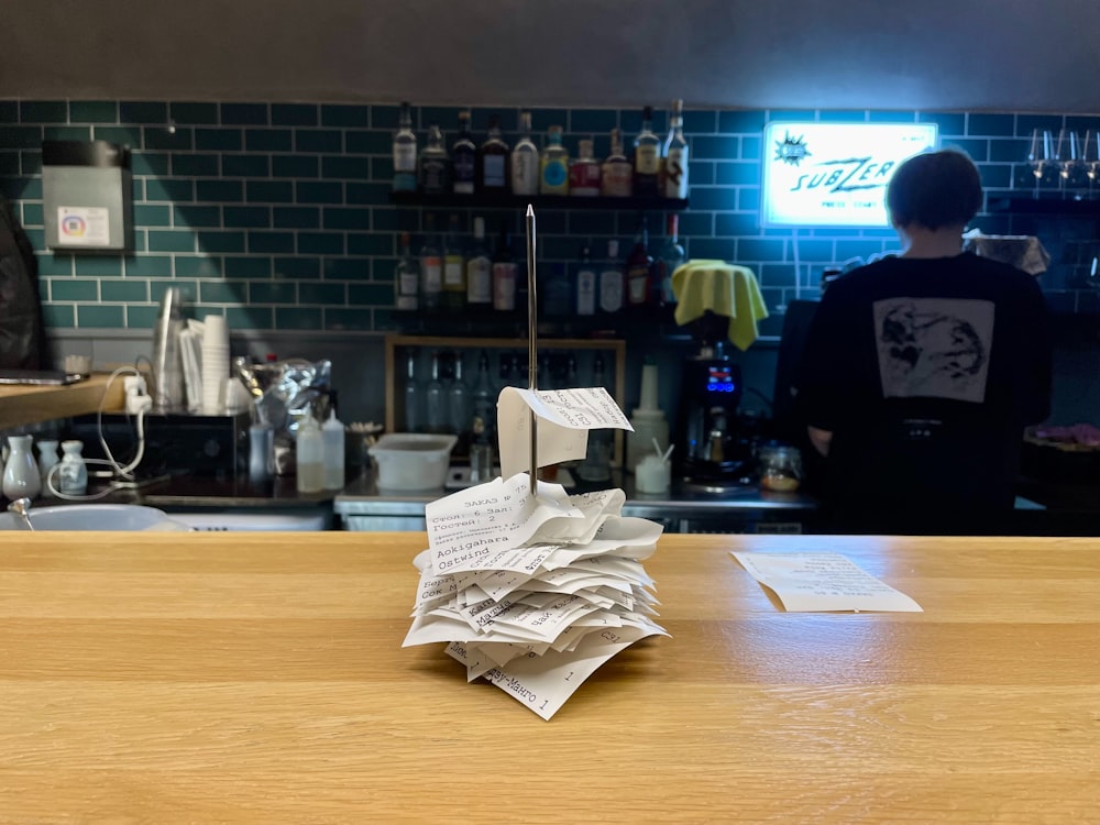 a stack of papers sitting on top of a wooden counter