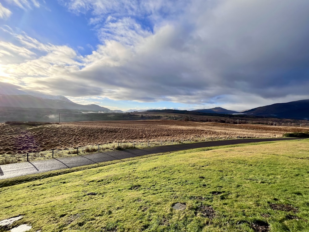 a grassy field with mountains in the background