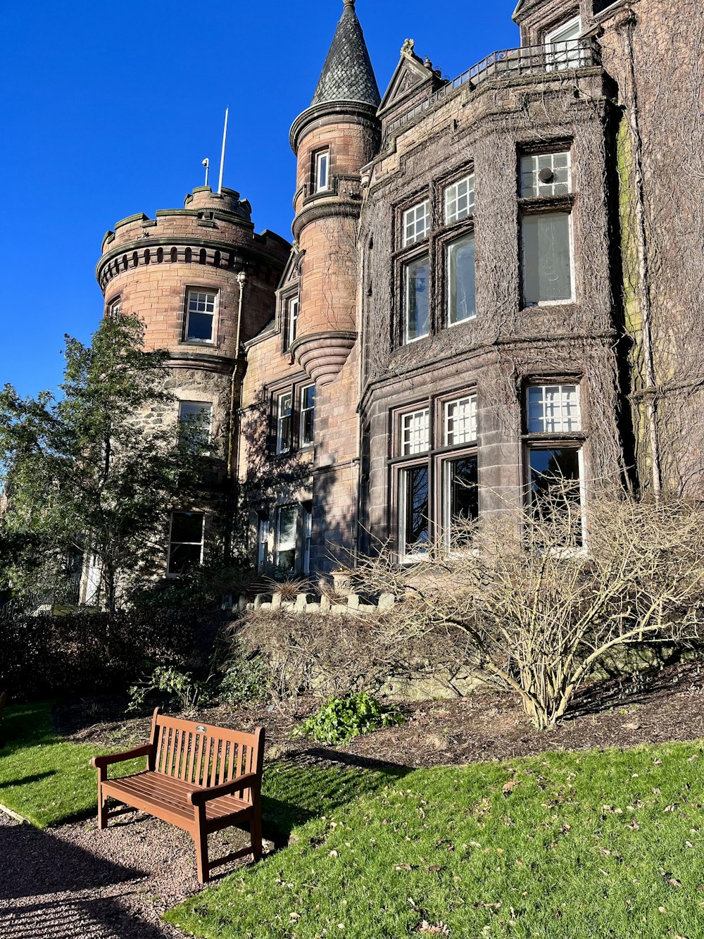 a wooden bench sitting in front of a tall building