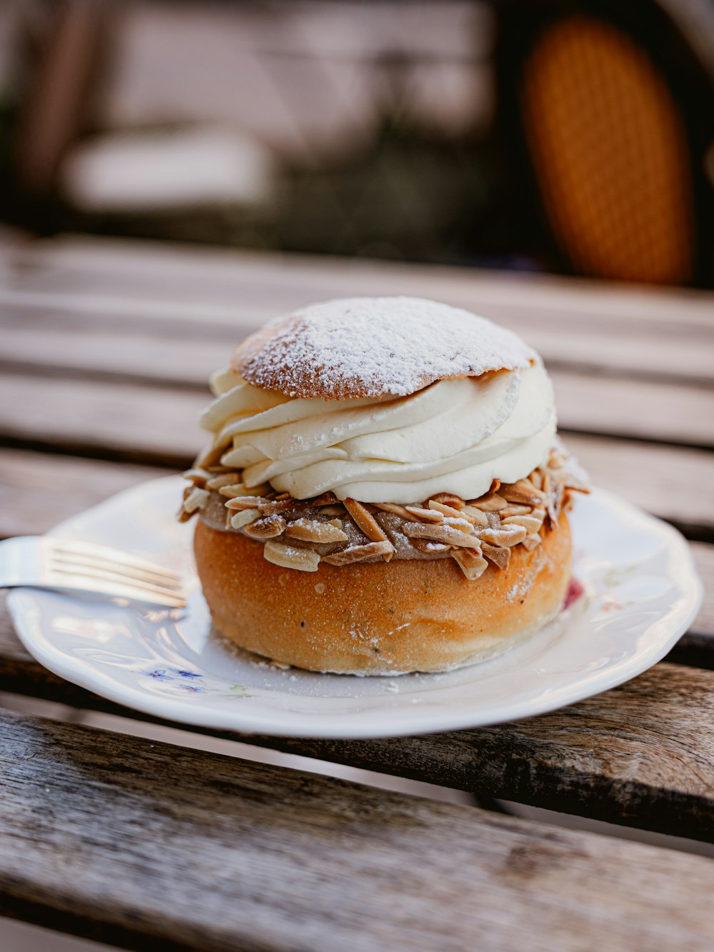 a pastry sitting on top of a white plate on top of a wooden table