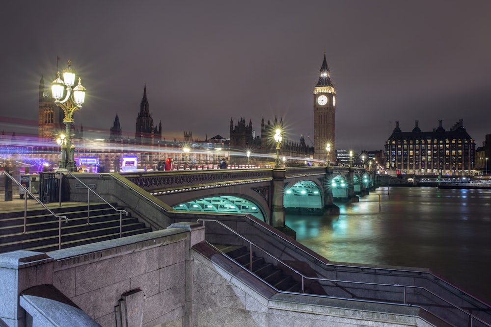 a view of a bridge and a clock tower at night