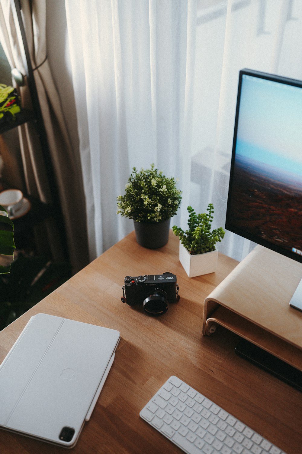 a desk with a laptop, keyboard and a monitor