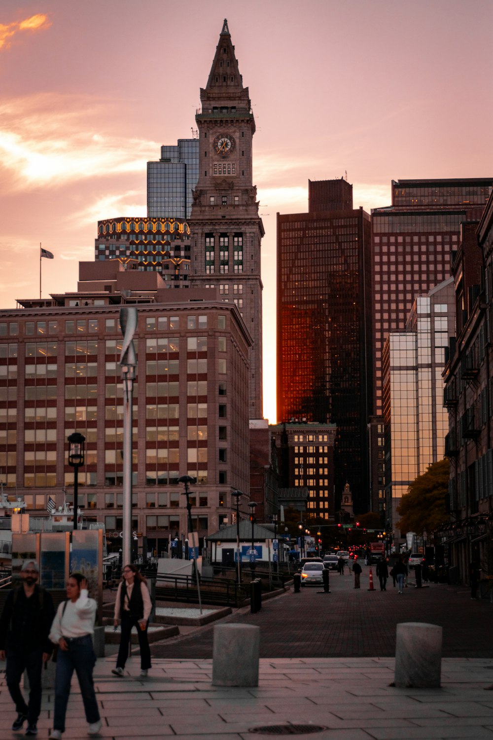 a group of people walking down a street next to tall buildings