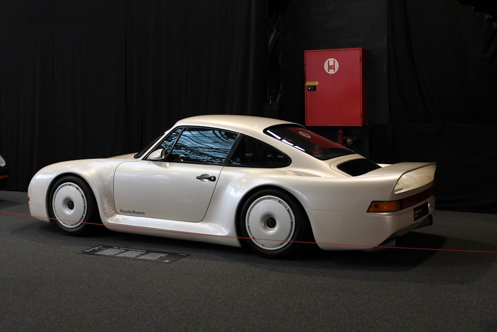 a white sports car is on display at a car show