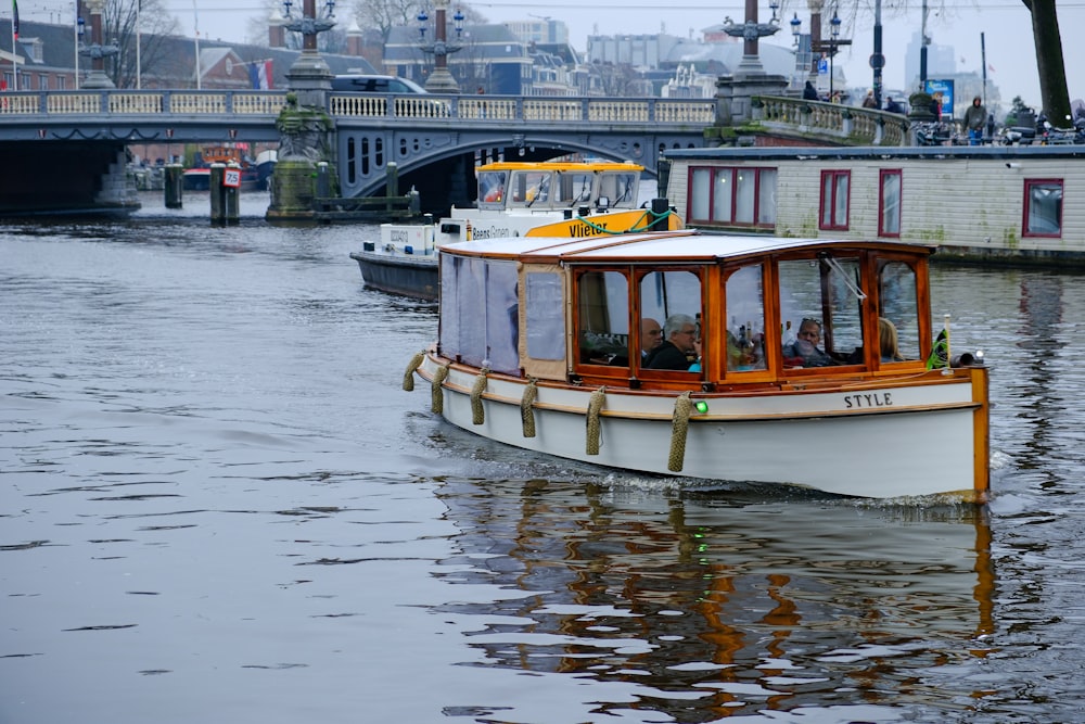 a small boat traveling down a river next to a bridge