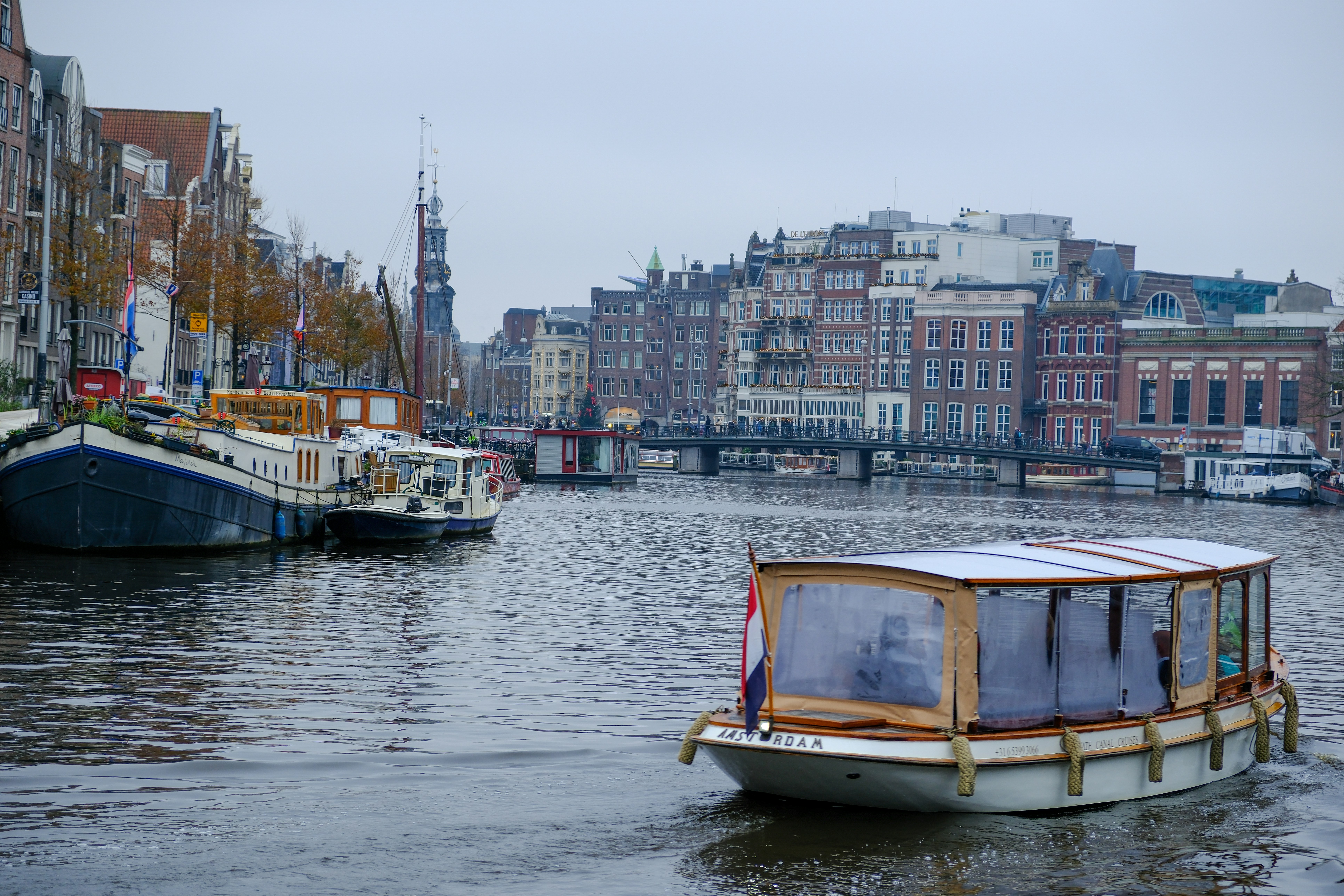 a boat floating on top of a river next to tall buildings