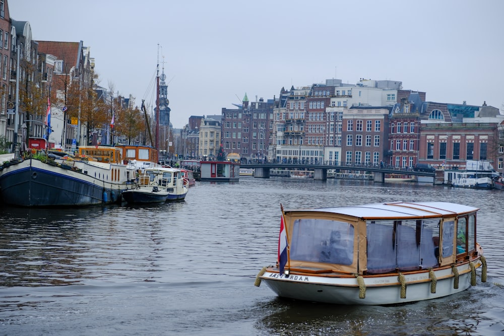 a boat floating on top of a river next to tall buildings