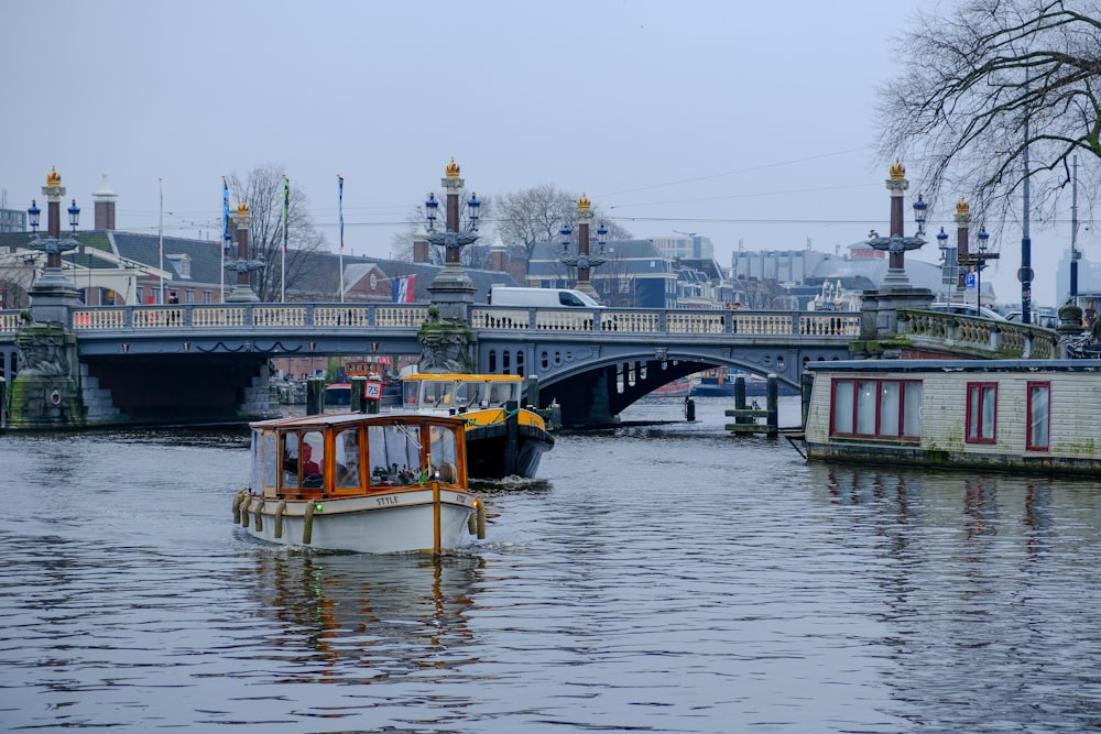 a boat traveling down a river next to a bridge