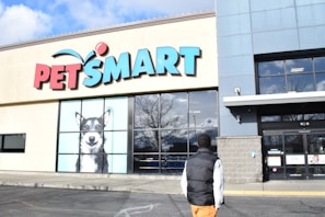 a man walking past a pet smart store