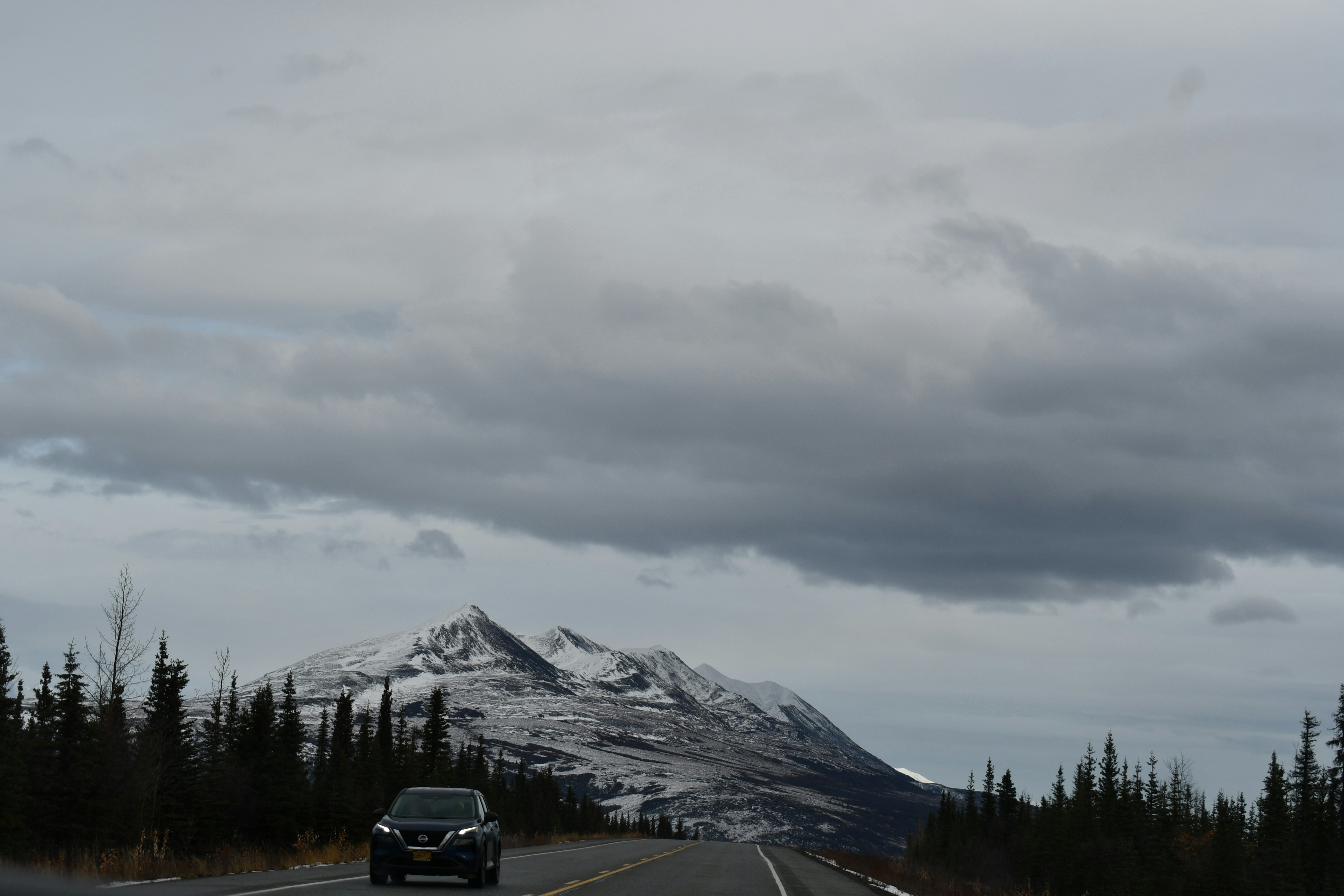 A car driving down a road with a mountain in the background photo ...