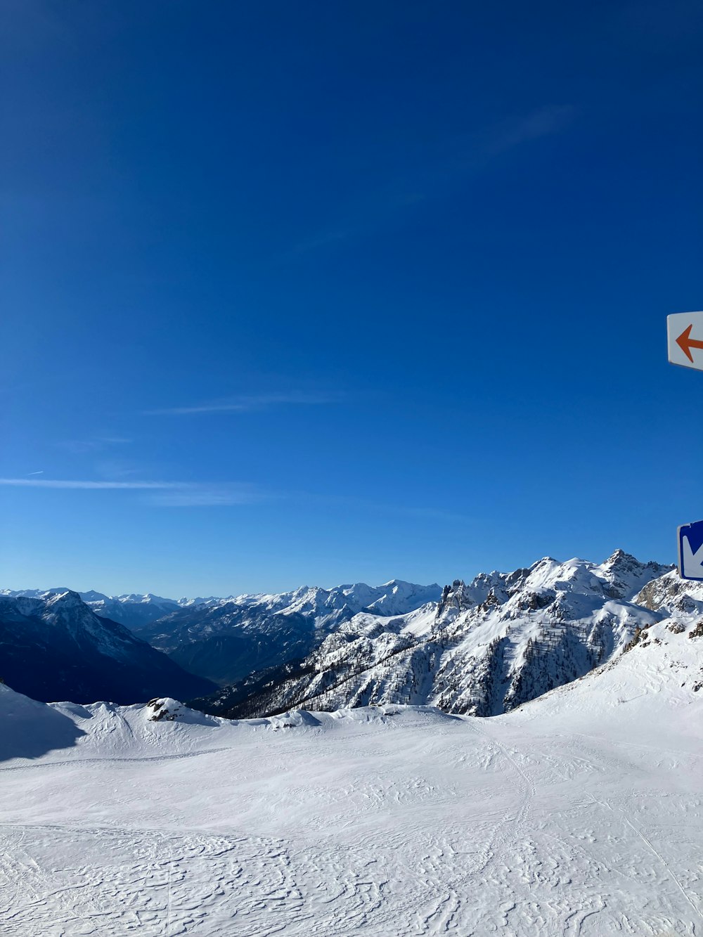 a sign on top of a snow covered mountain