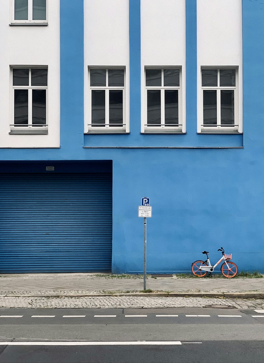 a bicycle parked next to a blue building
