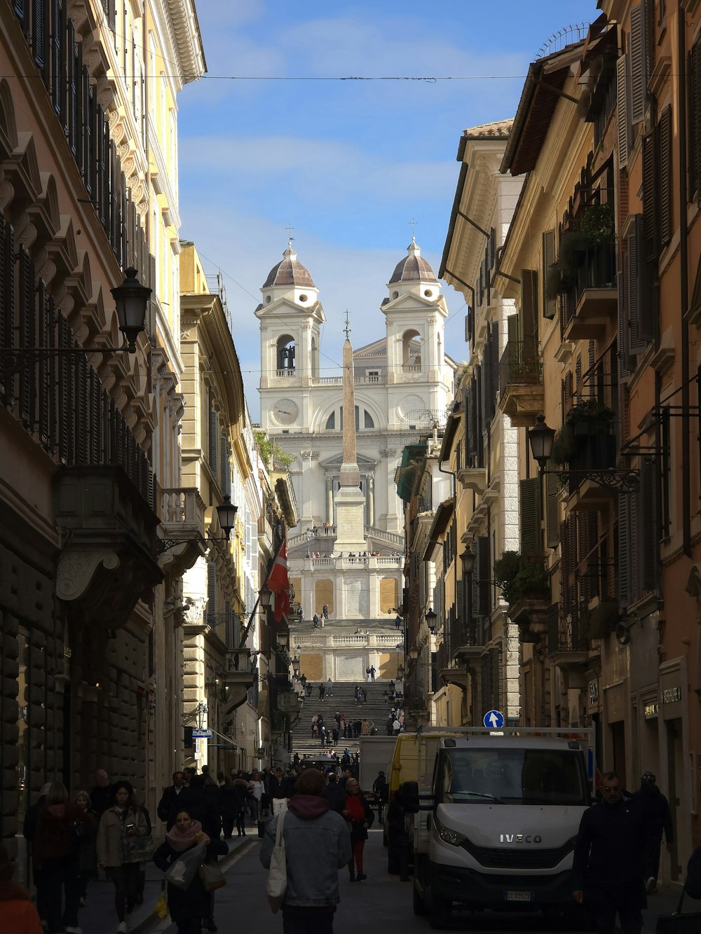 a narrow city street with a church in the background