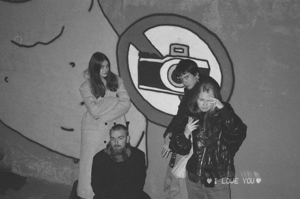 a group of people standing in front of a wall