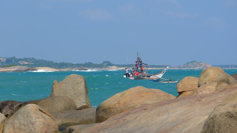 a boat is out on the water near some rocks