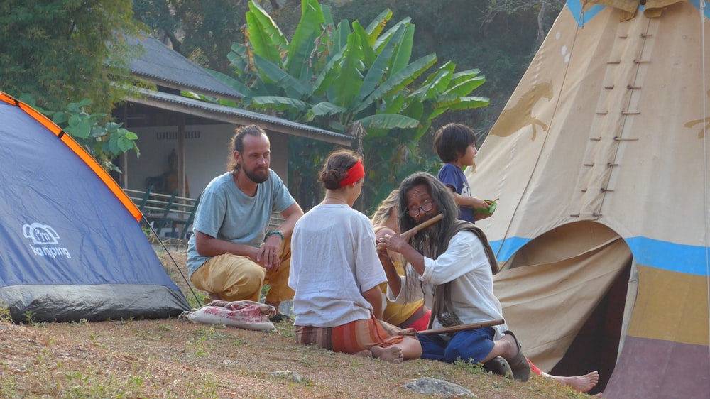 a group of people sitting around a tent