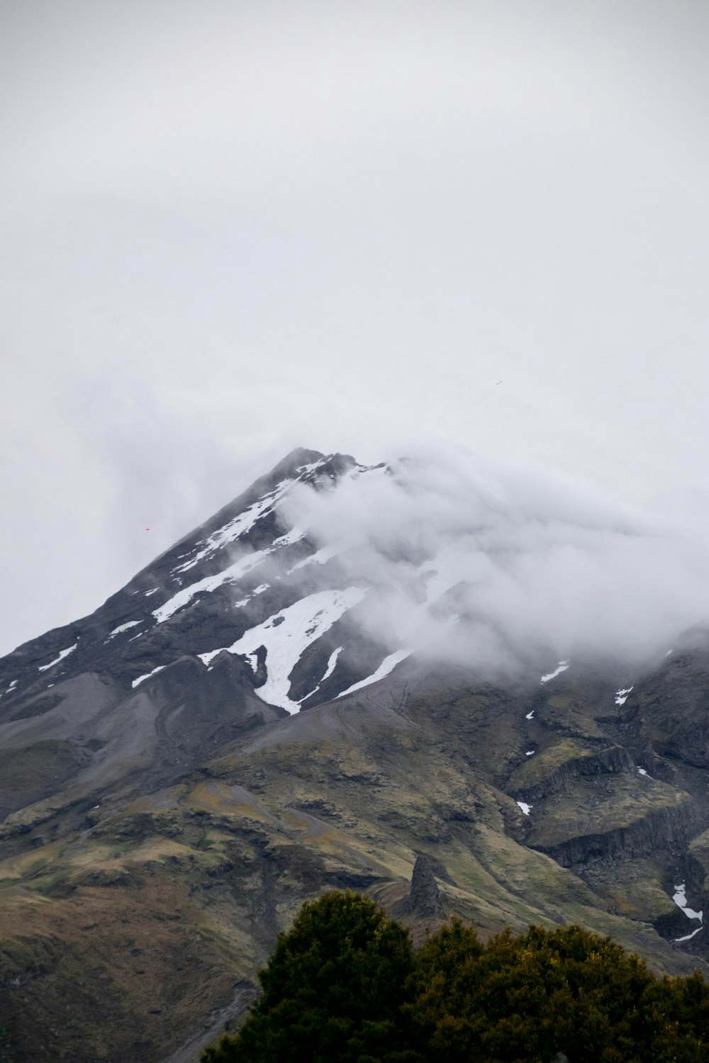 ein schnee- und wolkenbedeckter Berg an einem bewölkten Tag