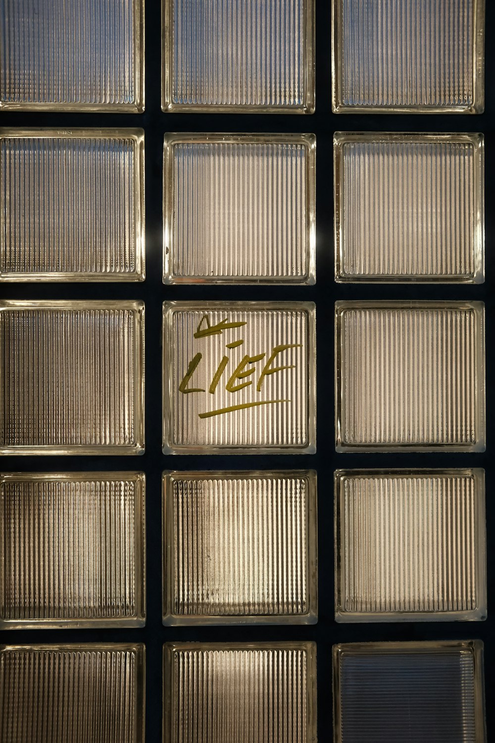 a close up of a glass block wall with writing on it