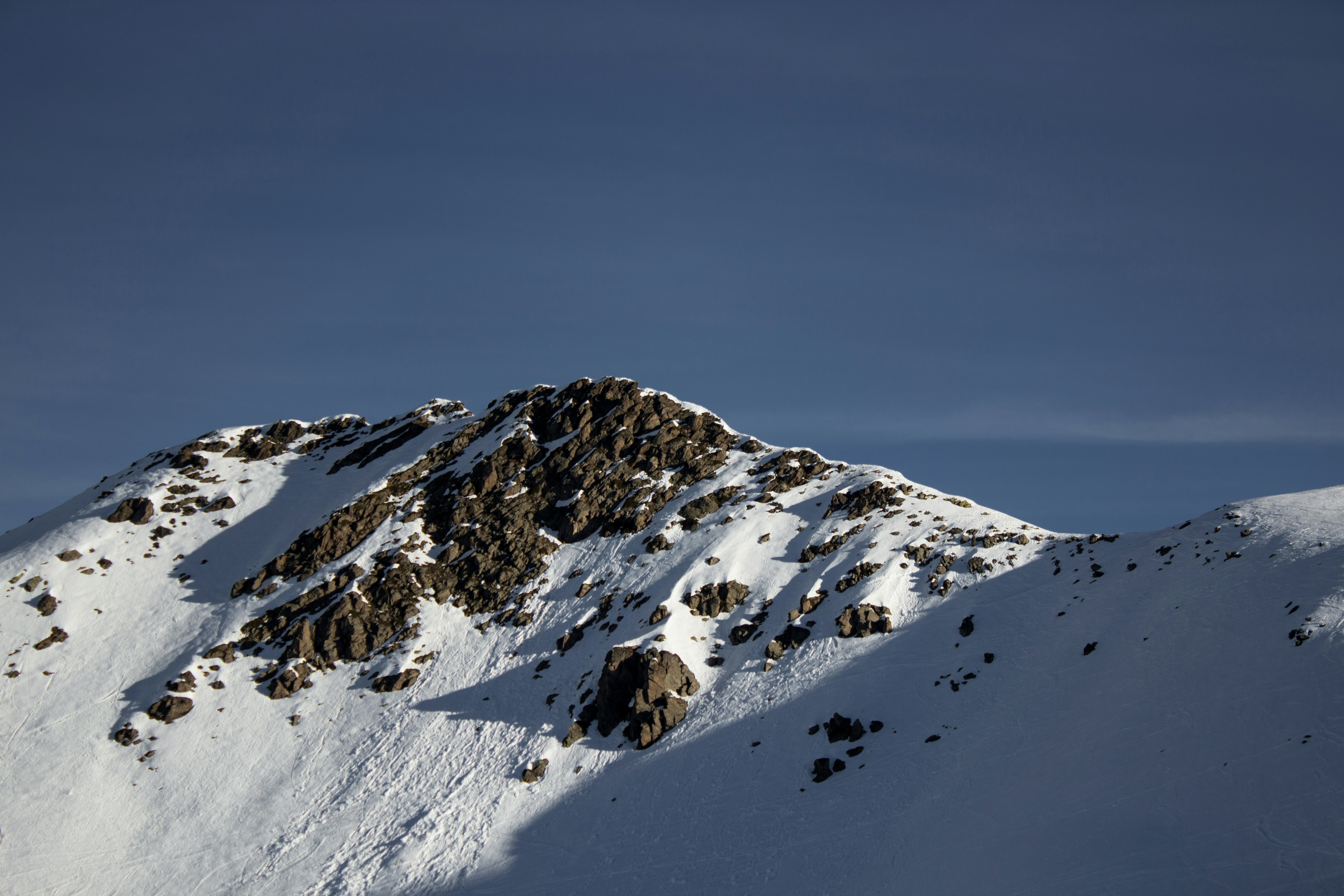 a mountain covered in snow with a sky background