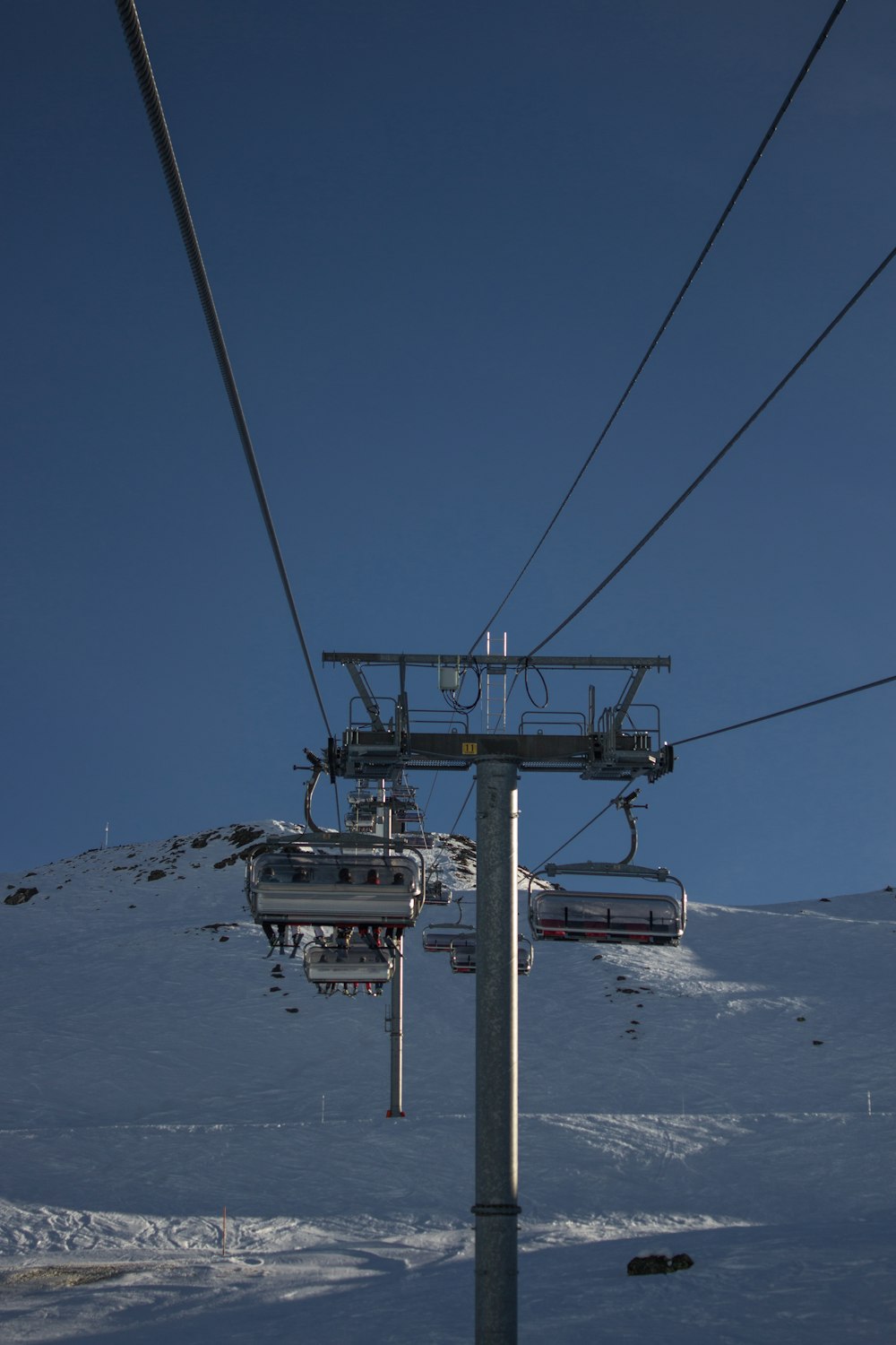 a ski lift going up the side of a snow covered mountain