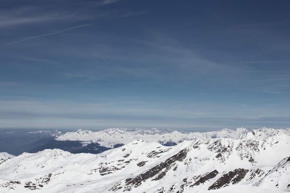 a view of a snowy mountain range from the top of a mountain