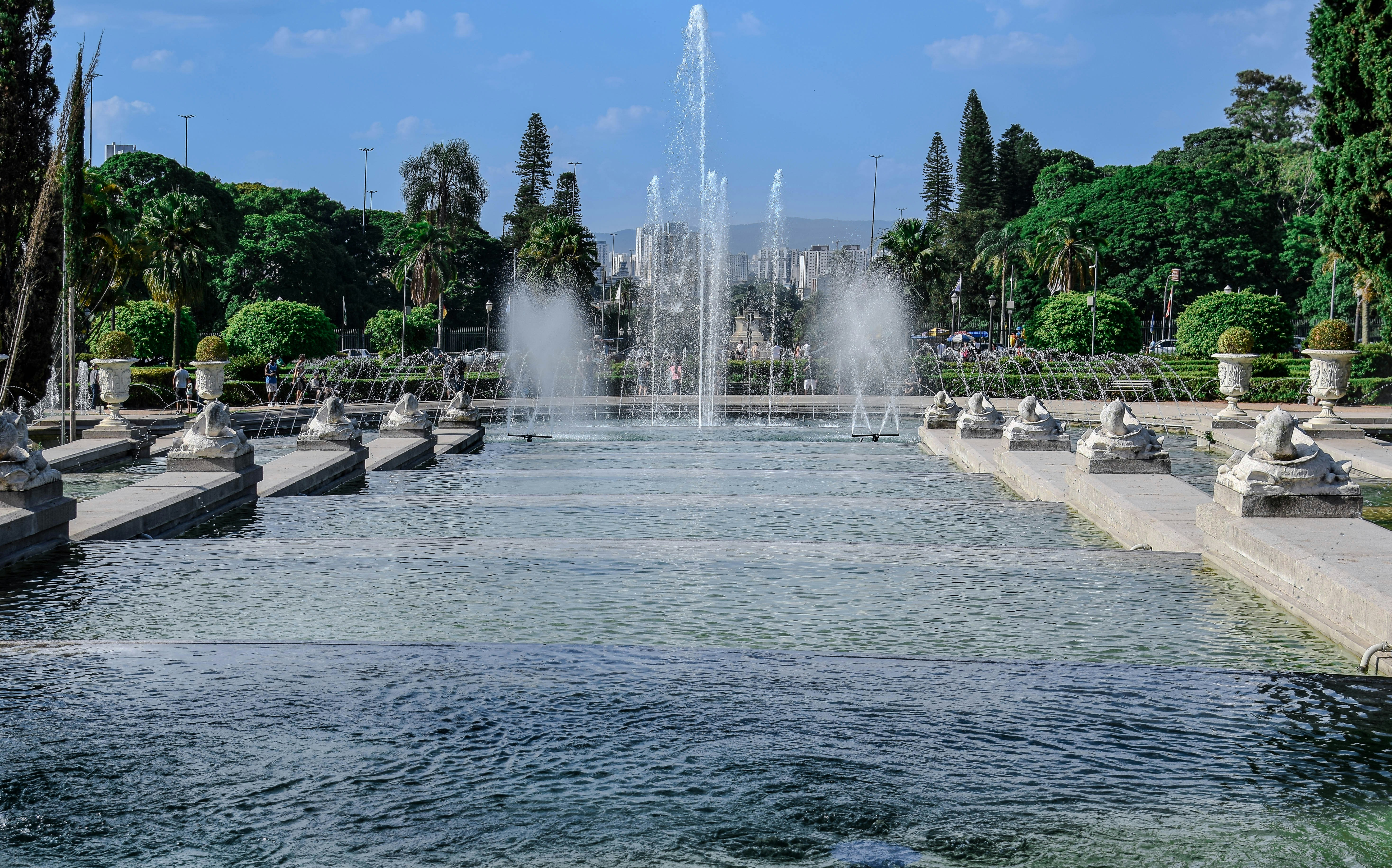 a water fountain in a park surrounded by trees