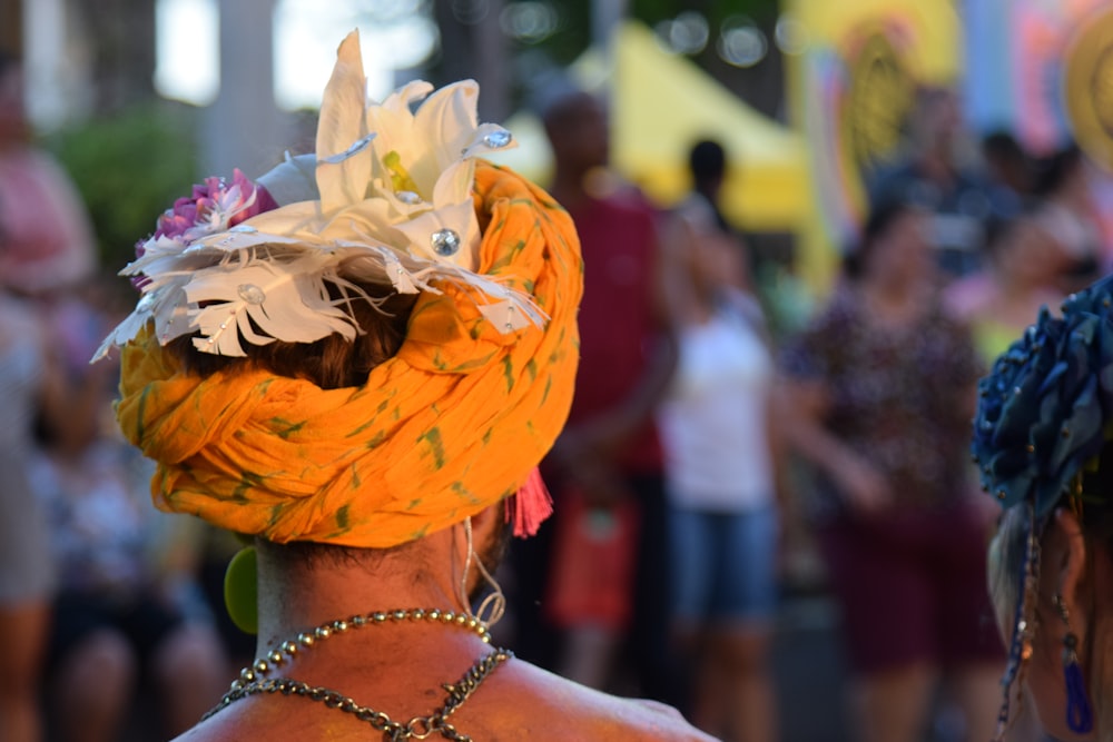 a woman wearing a yellow head scarf and a flower in her hair