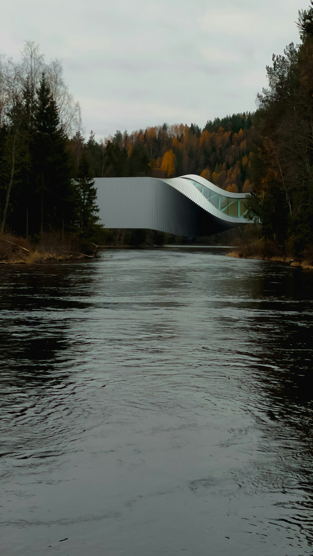 un pont au-dessus d’une rivière avec un bâtiment en arrière-plan