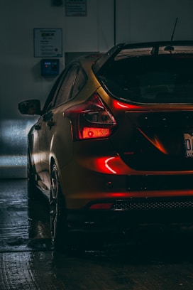 a car parked in a garage with its lights on