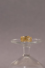 a gold ring sitting on top of a glass vase