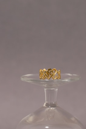 a gold ring sitting on top of a glass vase