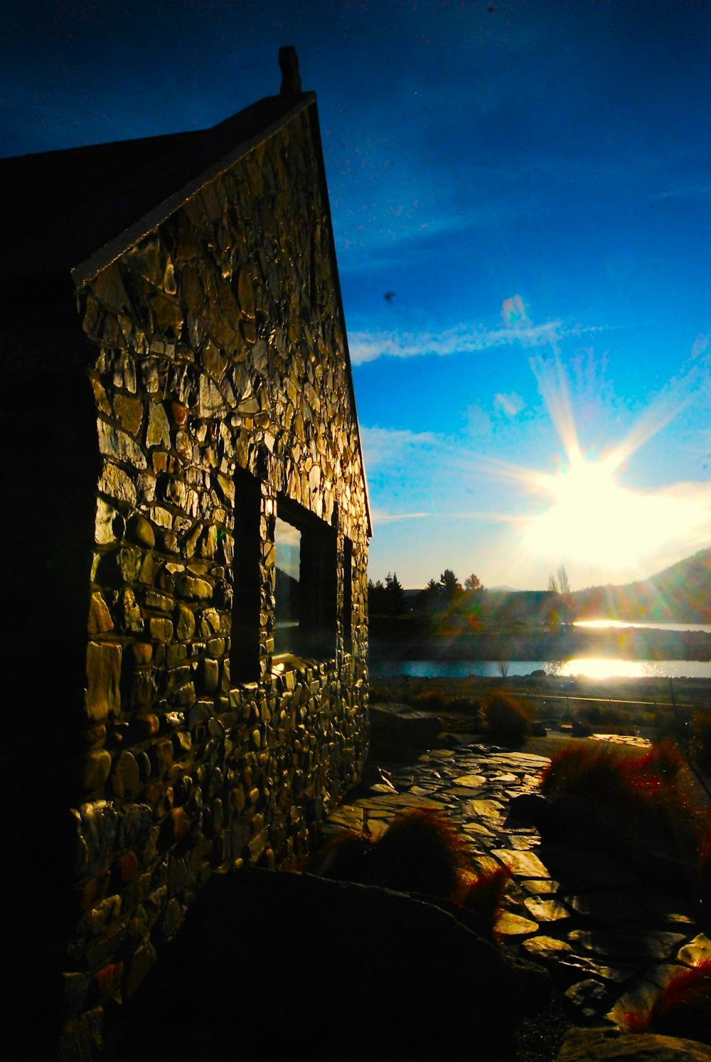 a stone building sitting next to a body of water