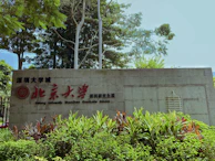 a sign in front of some bushes and trees