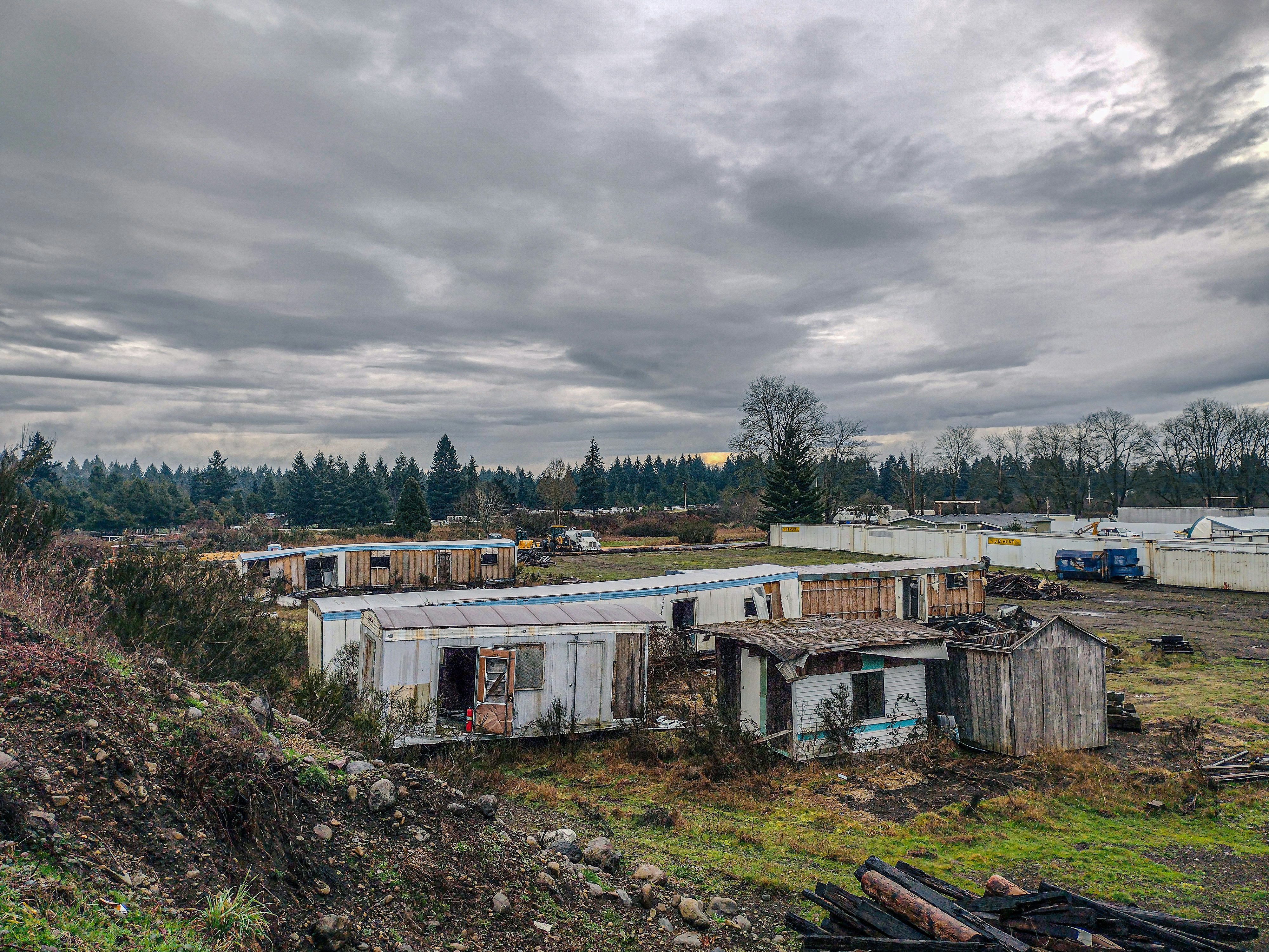 a group of shacks sitting on top of a lush green field