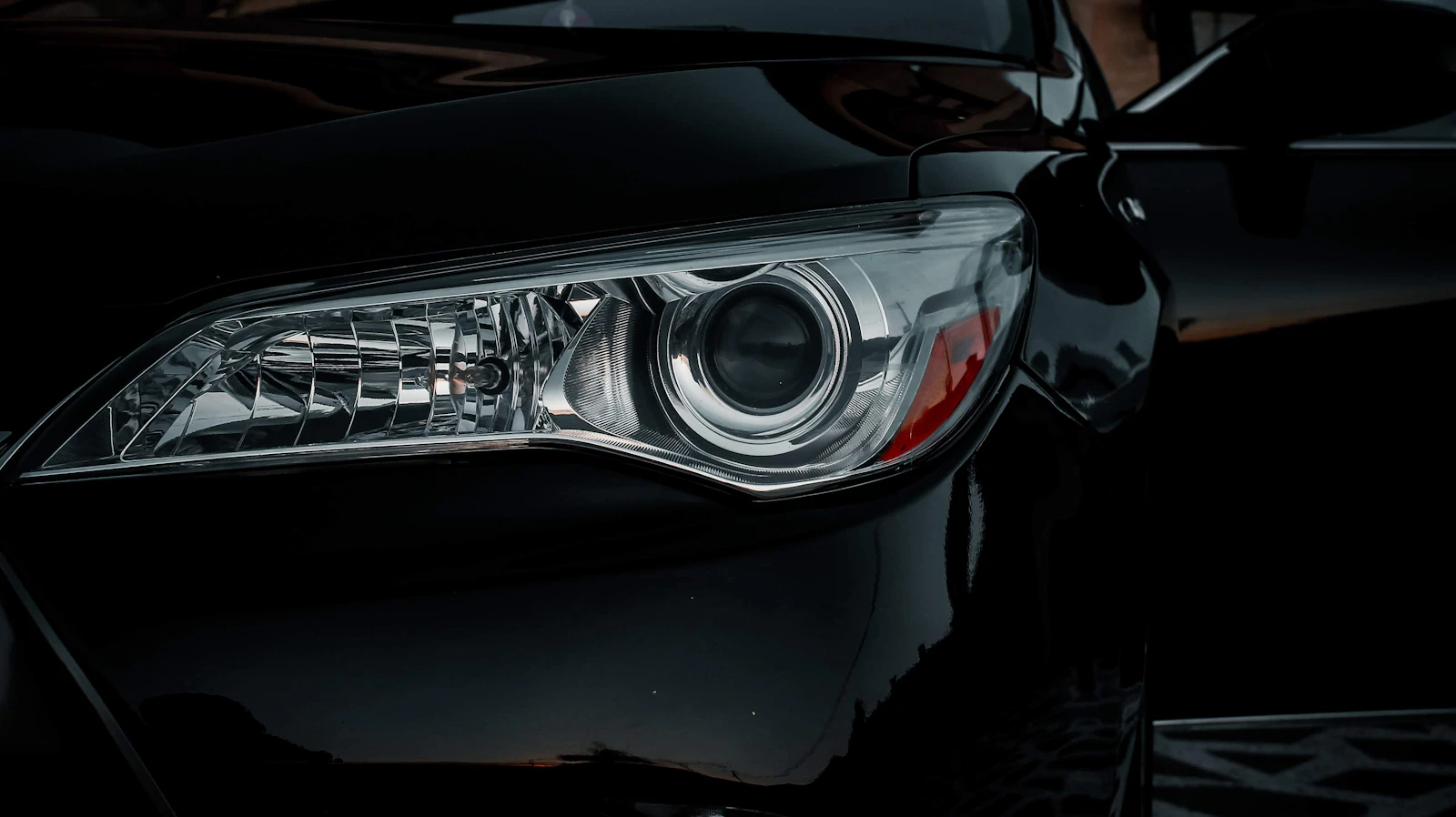 Headlights of a dark car glowing in the night