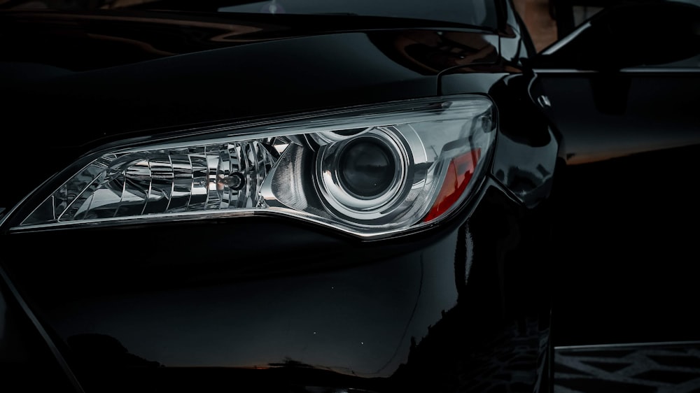 a close up of a car headlight on a black car