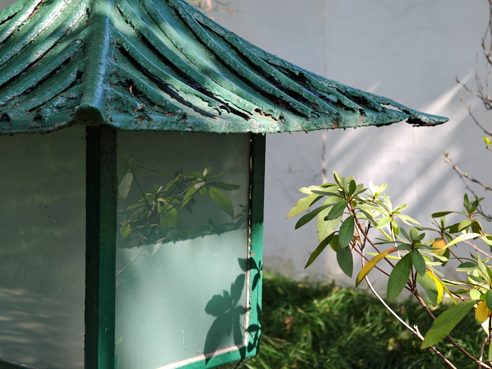 a close up of a bird house with a tree in the background