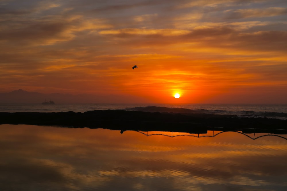 the sun is setting over a body of water