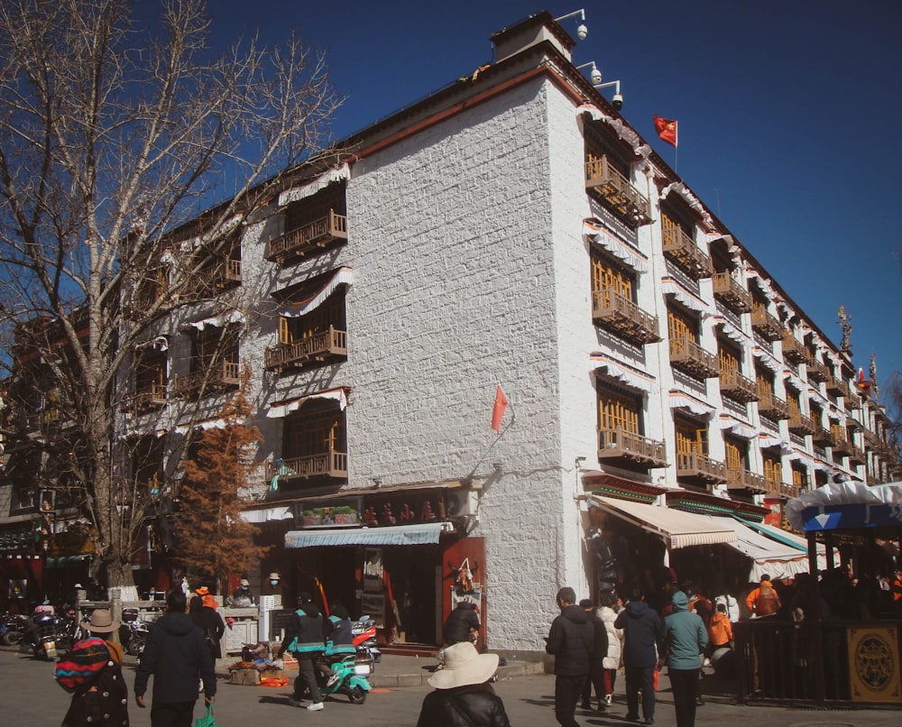 a group of people standing outside of a white building