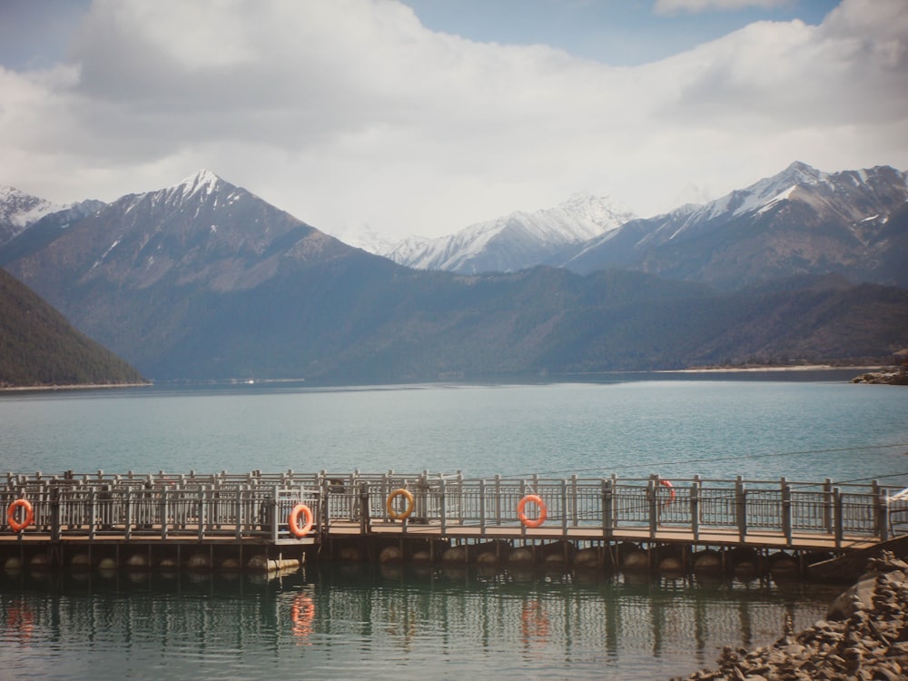 a bridge over a body of water with mountains in the background